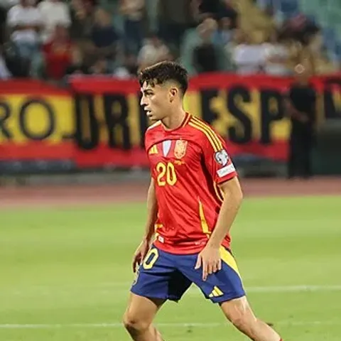 Pedri in Spain's red shirt — the Barcelona midfielder is one of eight Barça players in Luis de la Fuente's 26-man Spain squad for the 2026 World Cup announced at Espacio Movistar Madrid on May 25, a squad that includes Lamine Yamal despite a hamstring injury, brings Gavi back after the cruciate ligament rebuild, and pointedly excludes every Real Madrid player including Dani Carvajal and Dean Huijsen