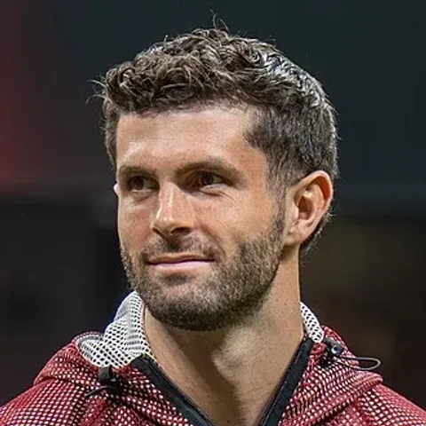 Christian Pulisic in the USMNT shirt — the AC Milan winger is the senior creative lead in Mauricio Pochettino's 26-man squad for the 2026 World Cup, announced by U.S. Soccer in New York on the afternoon of Tuesday May 26 ahead of the host-nation opener vs Paraguay at SoFi Stadium on Friday June 12
